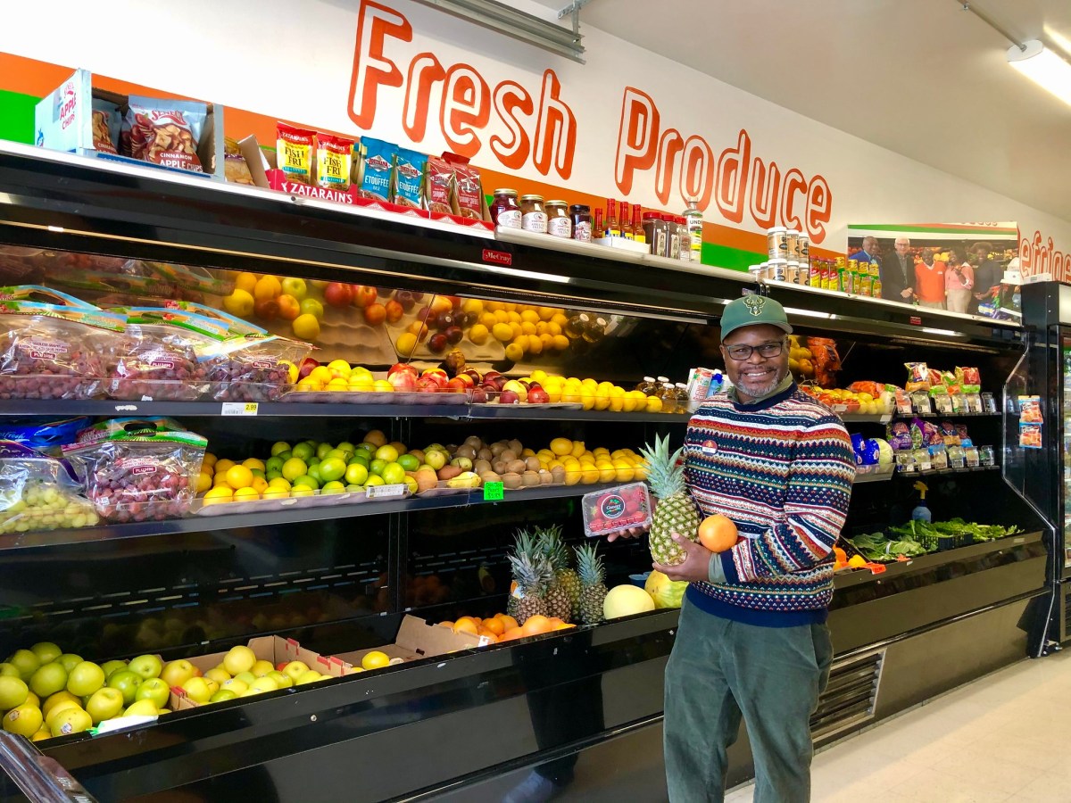 Man holds groceries in store aisle.
